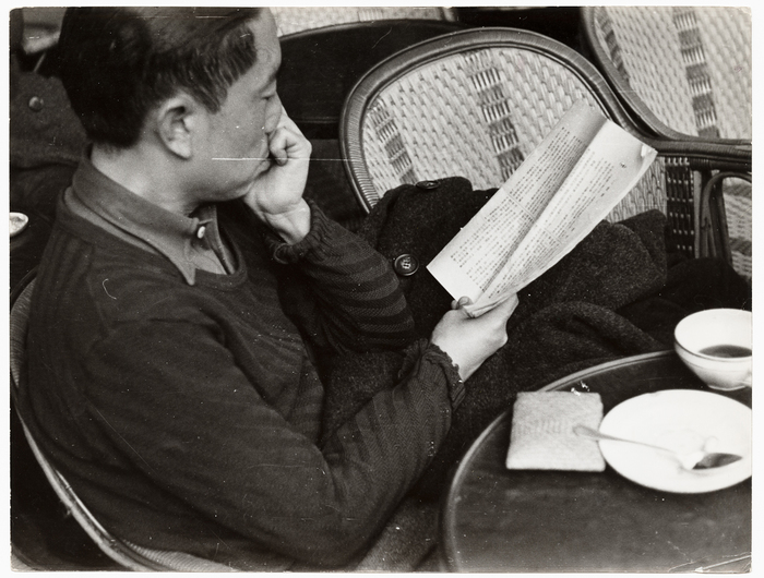 [Man reading Japanese paper at a cafe, Paris]