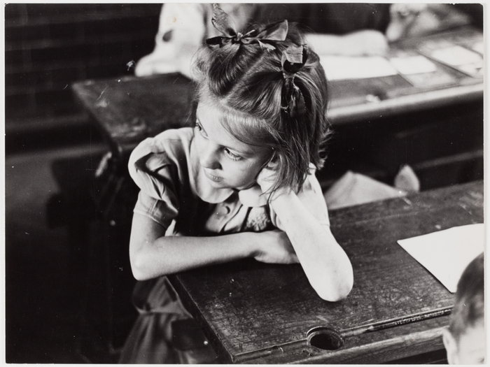 [Girk at a school desk, England]