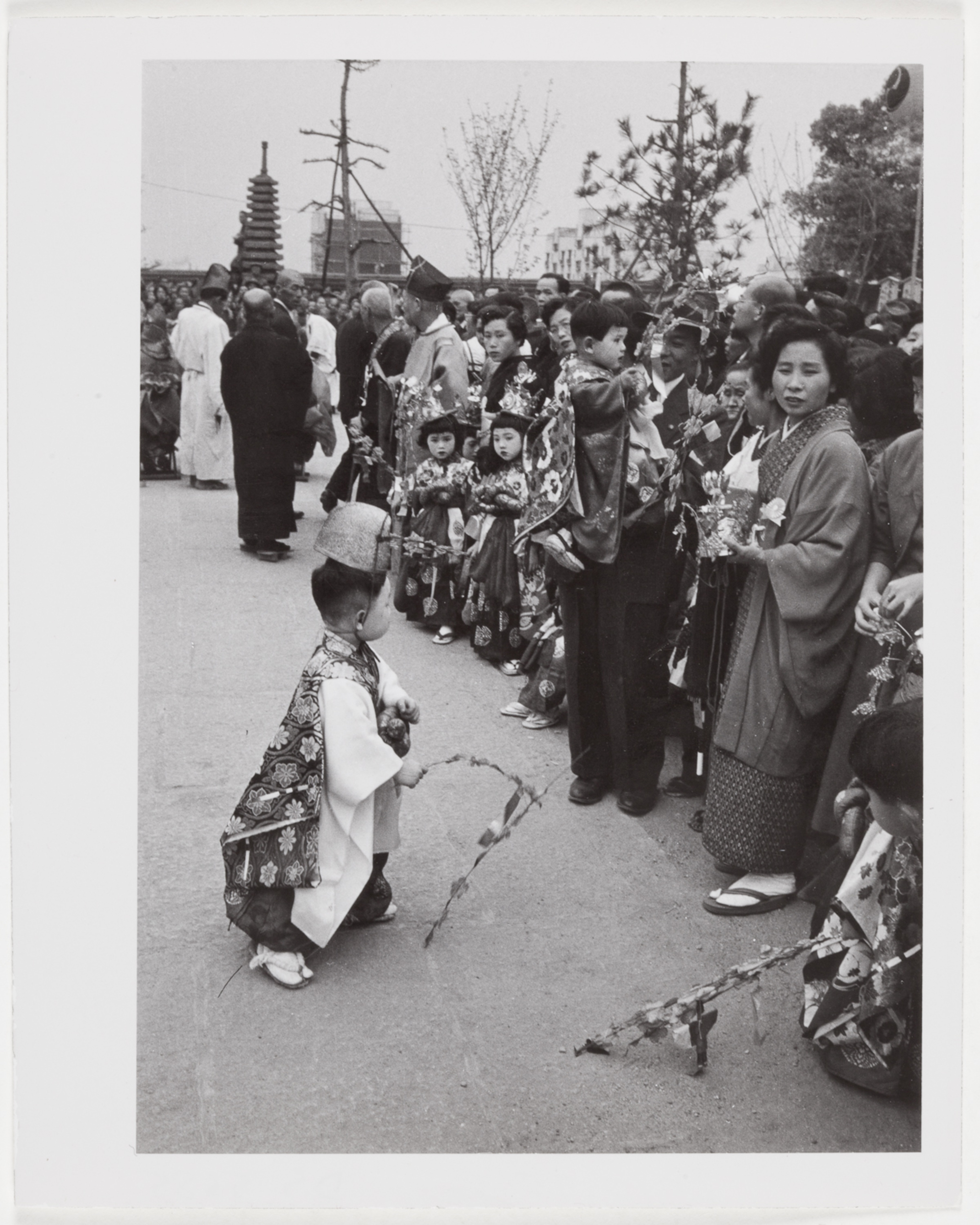 [Child in Japanese traditional costume facing other children in line in