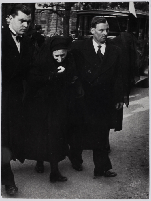 [Mourning woman being held up by two men, Clichy, France]