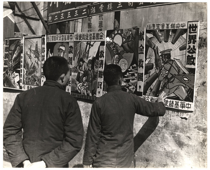 [Men looking at propaganda posters of atrocities of Japanese invasion, Hankou, China]