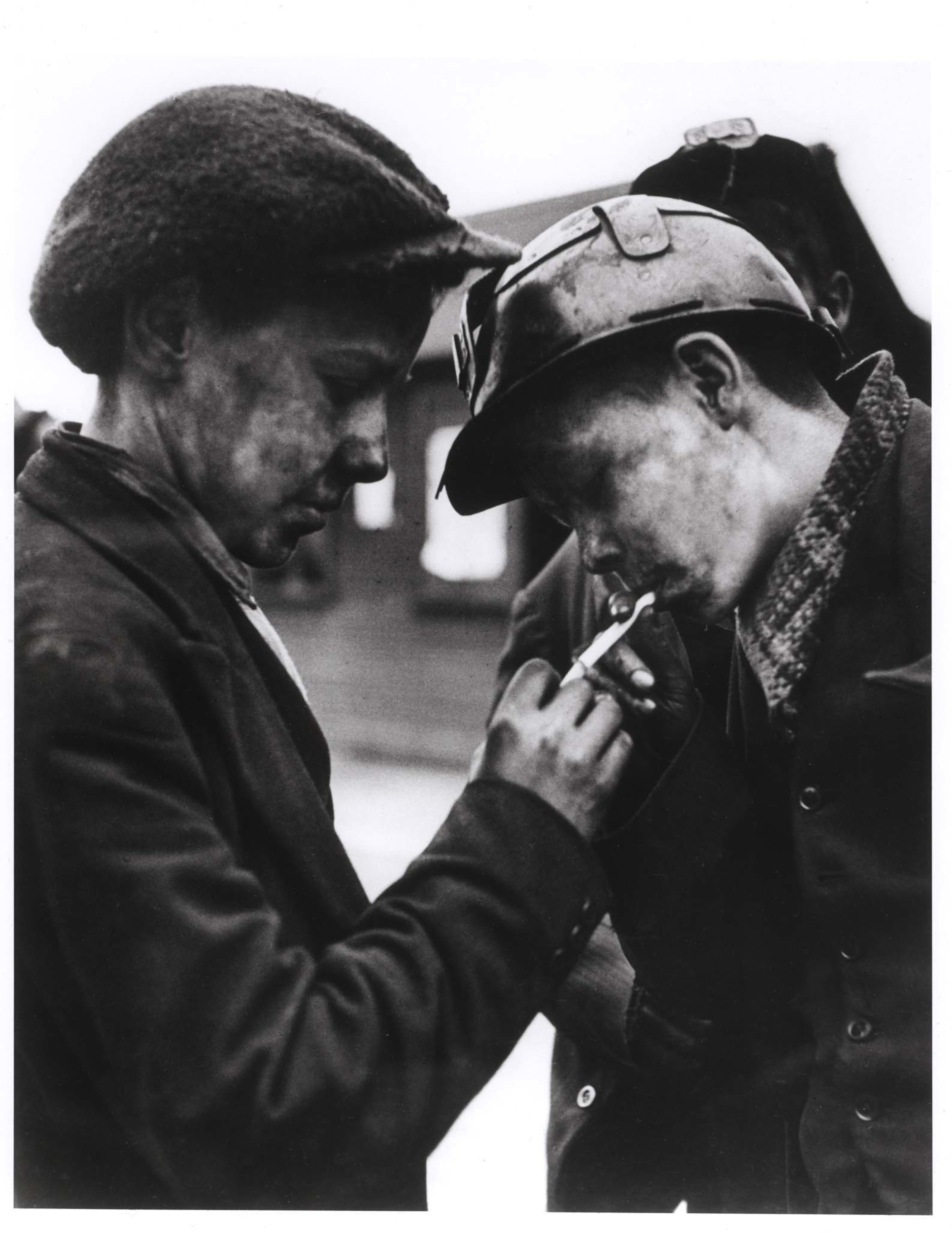 [Coal miner lighting cigarette for another miner in the area where "How