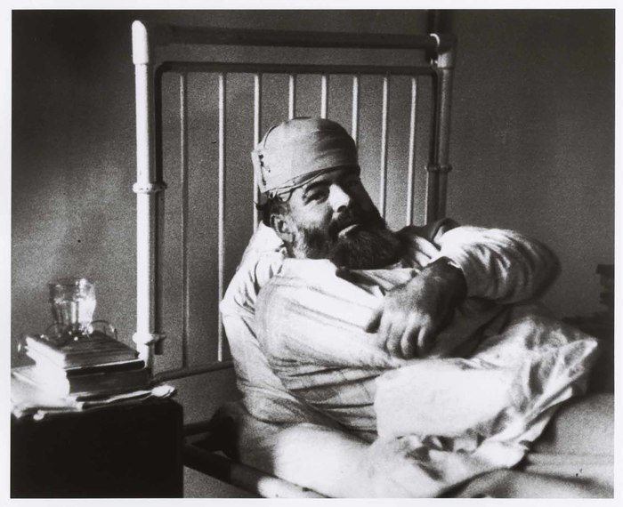 [Ernest Hemingway recovering from injuries sustained in a car accident after a party given by Capa. London, England]