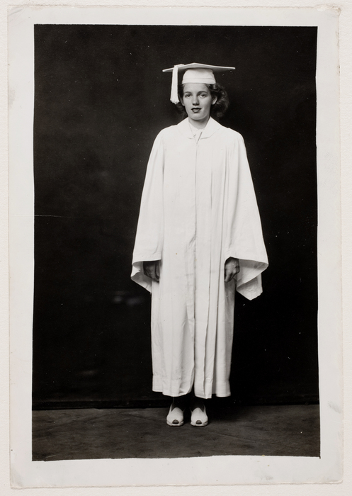 [Woman in white graduation cap and gown]