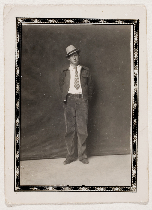 [Unidentified man in hat and tie]