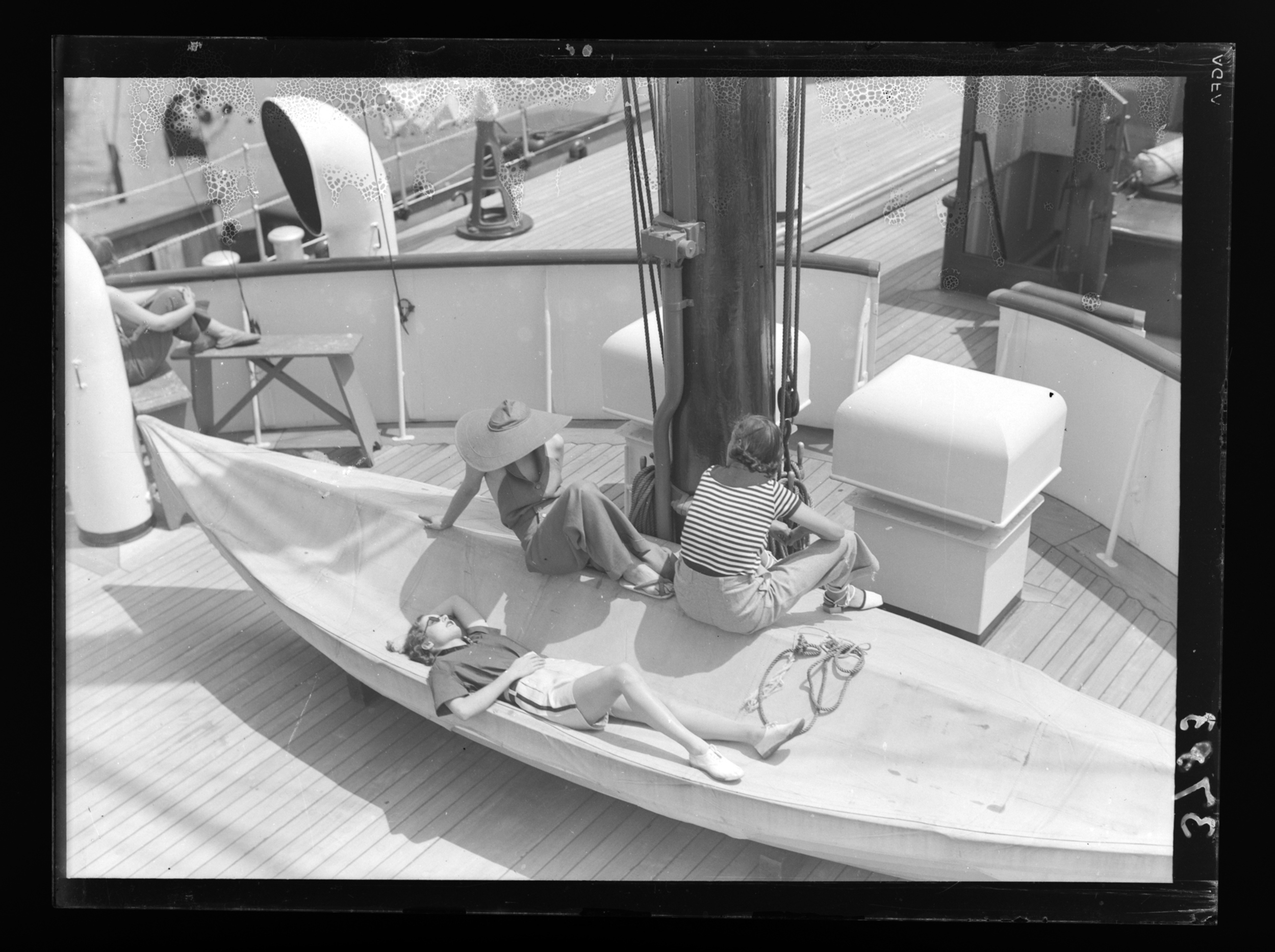 [Three women sunbathing on yacht deck] | International Center of