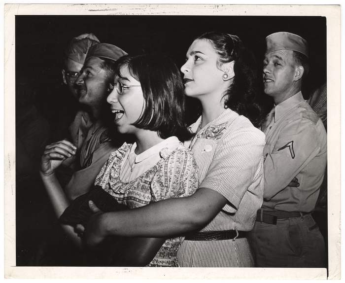 "The sirens also brought these girls, GI's, a dachshund and hundreds of others to the scene. The dog hid in a fire wagon."