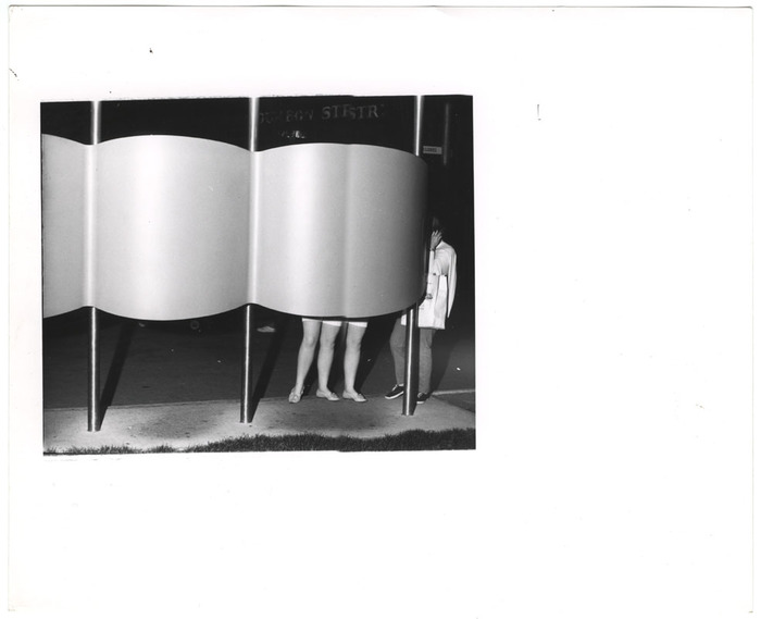 Woman with three legs at a phone booth (distortion)