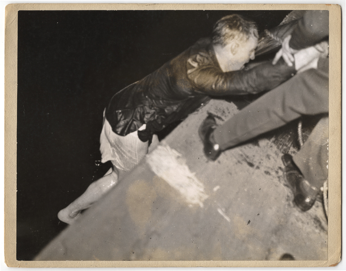 "Cop coming out of water, minus pants, after he had rescued woman"