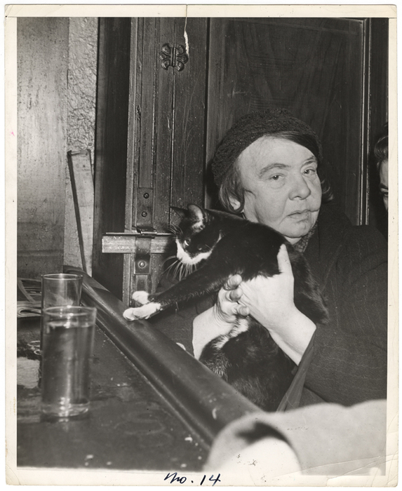 [Woman holding cat in bar]