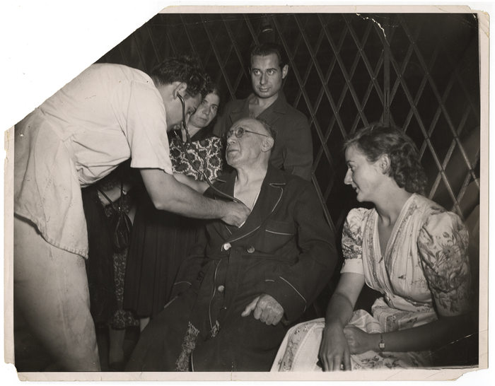 [Shirley Furhrer watching medic examine her crippled father after tenement fire, New York]