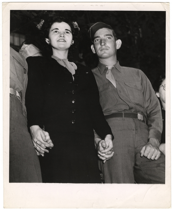 [Woman and military men holding hands]