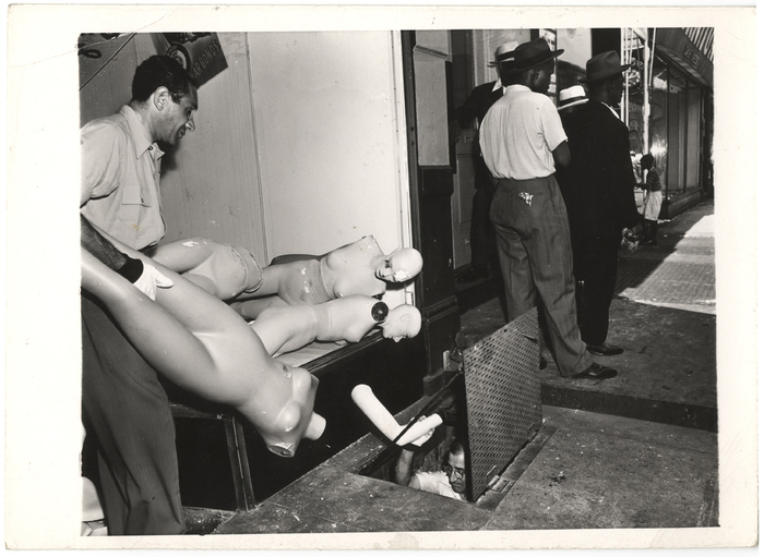 "Damaged dummies go into a basement for safekeeping in front of another clothing store on W. 116th St."