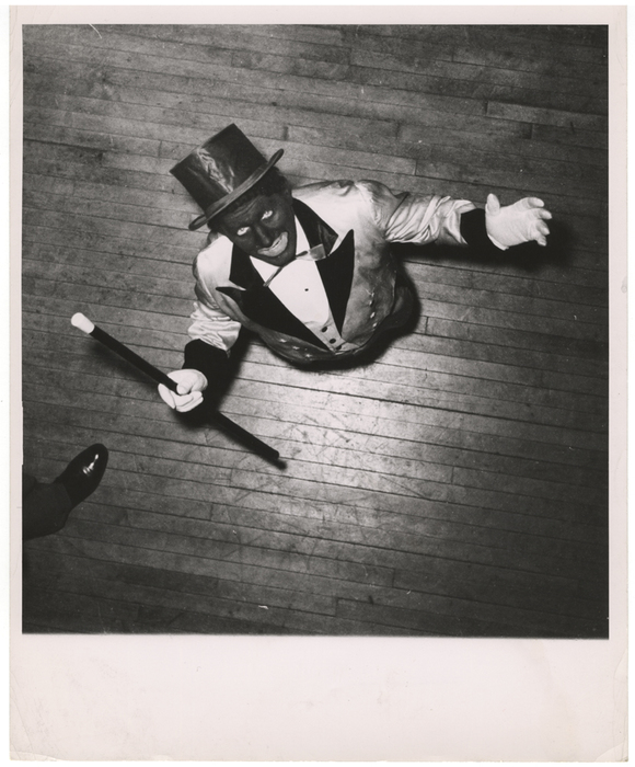 [man with blackface and top hat on stage]