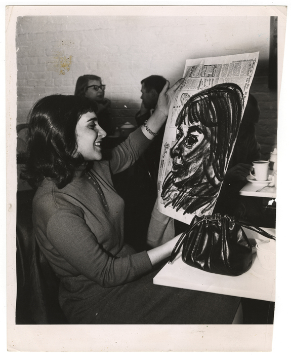 [woman holding portrait on newspaper at the Limelight]