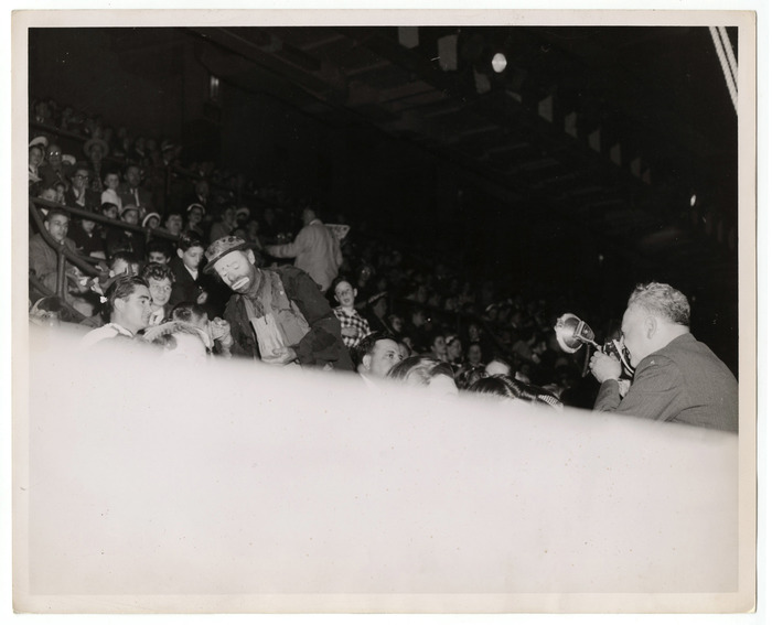 [Weegee photographing Emmett Kelly among audience members at circus]