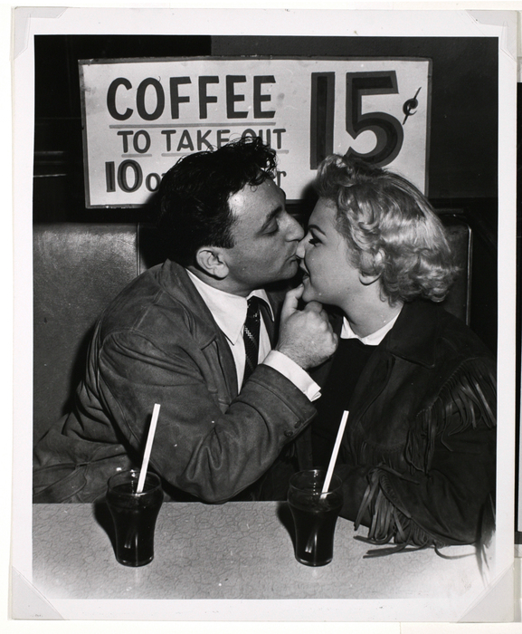 [Man kissing woman at drug store]