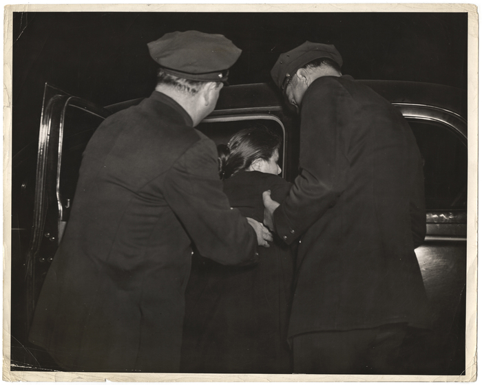 [Police officers holding a woman]