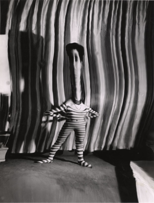 (Model wearing striped jumpsuit, with arms akimbo)