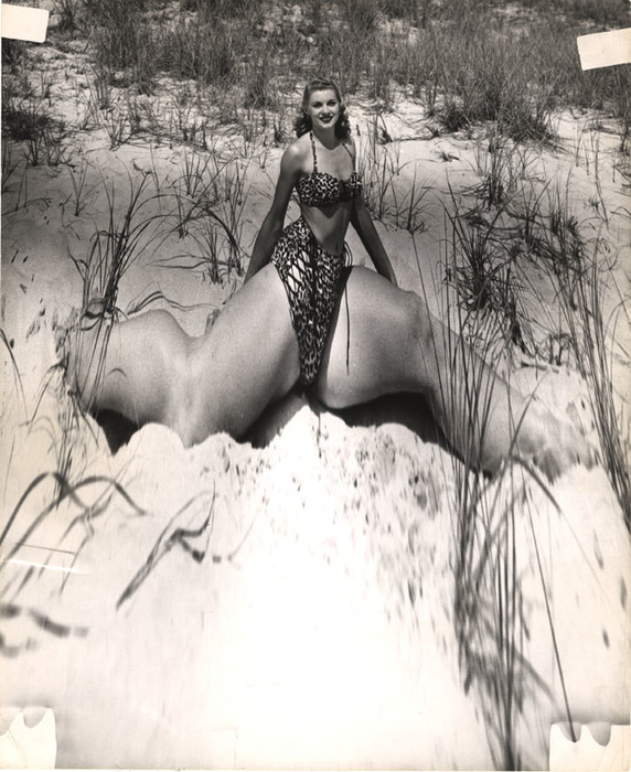 Blonde on beach sitting in the sand