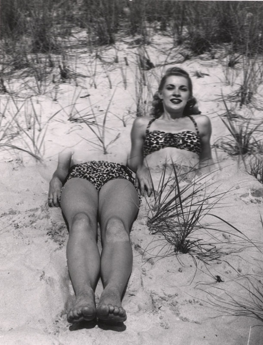 Blonde on beach sitting in the sand