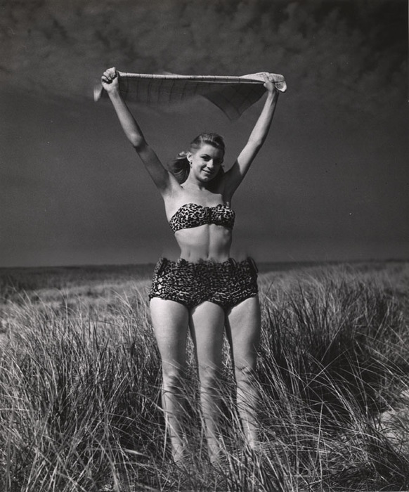 Blonde on beach standing and stretching