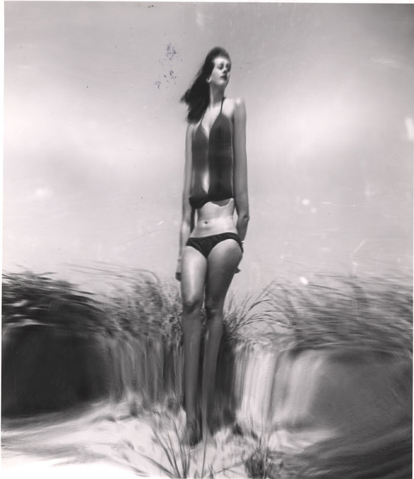 [Woman standing on the sand]