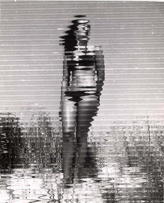 (Model on beach, wearing black bikini)