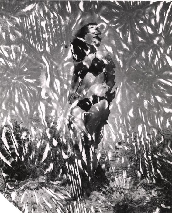 (Model on beach, wearing black bikini)