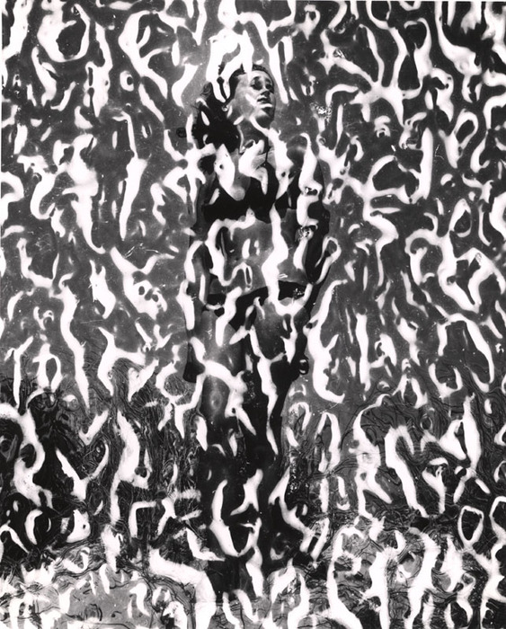 (Model on beach, wearing black bikini)