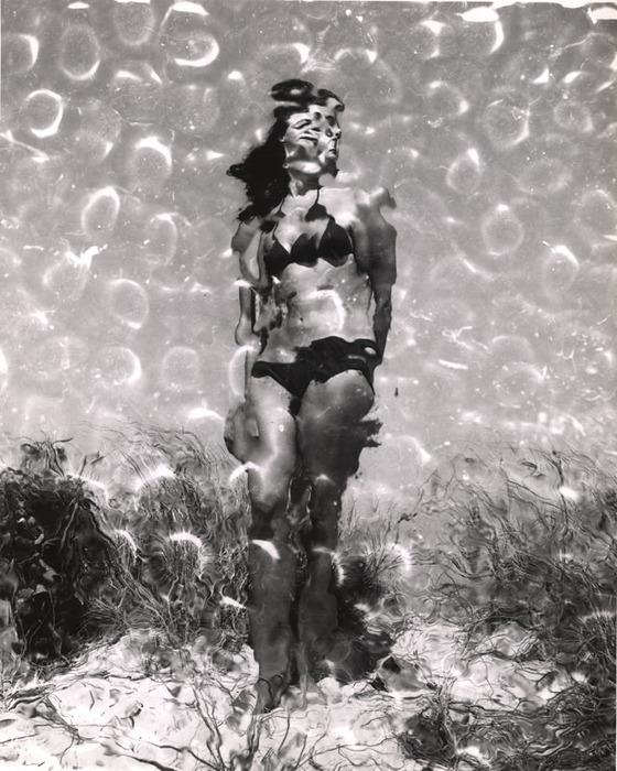 (Model on beach, wearing black bikini)