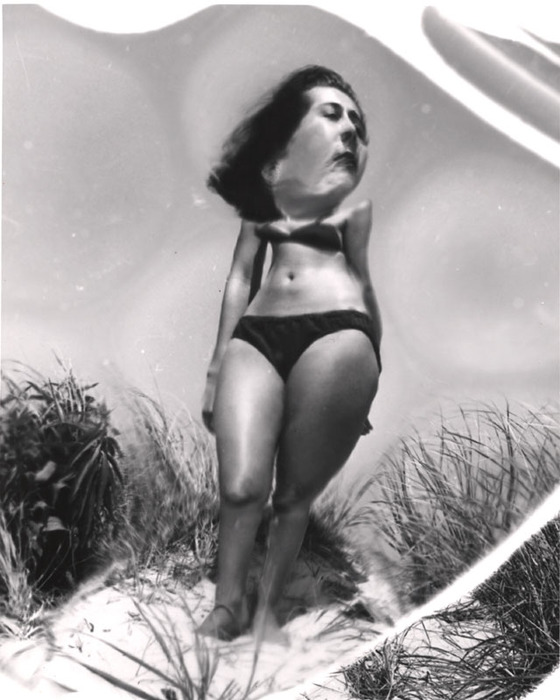 (Model on beach, wearing black bikini)