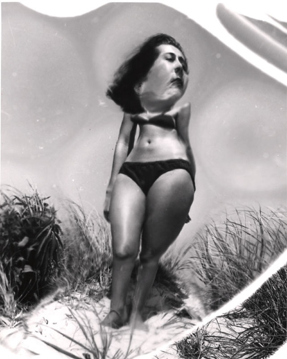 (Model on beach, wearing black bikini)