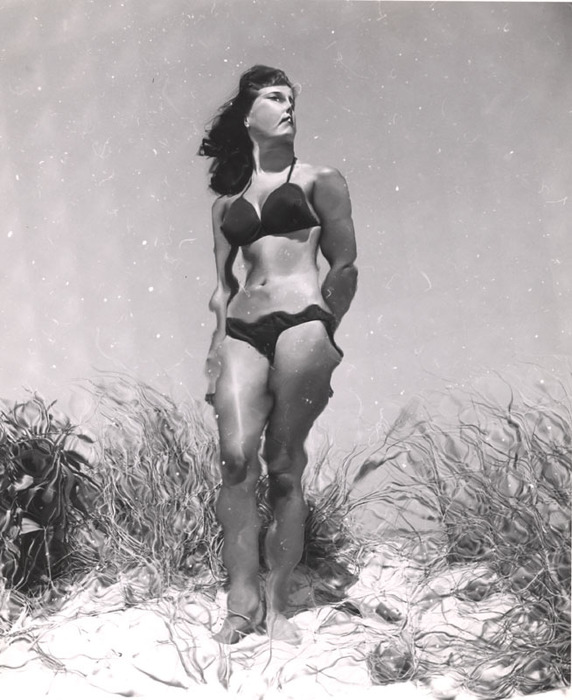 (Model on beach, wearing black bikini)