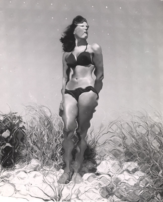 (Model on beach, wearing black bikini)