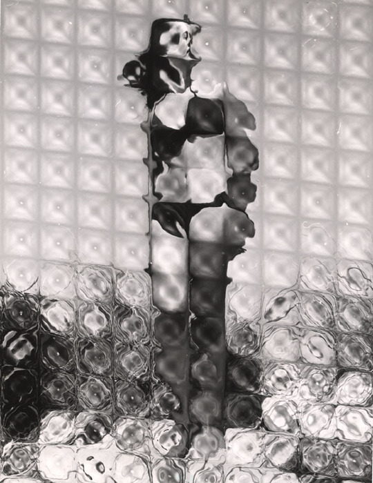 (Model on beach, wearing black bikini)