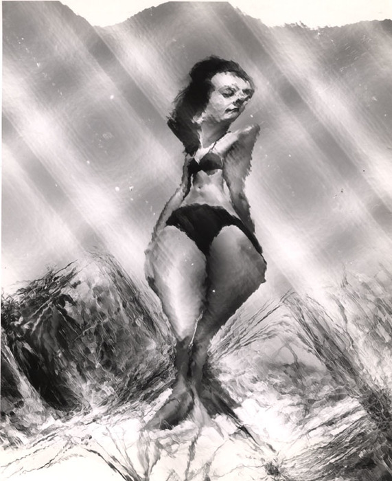 (Model on beach, wearing black bikini)