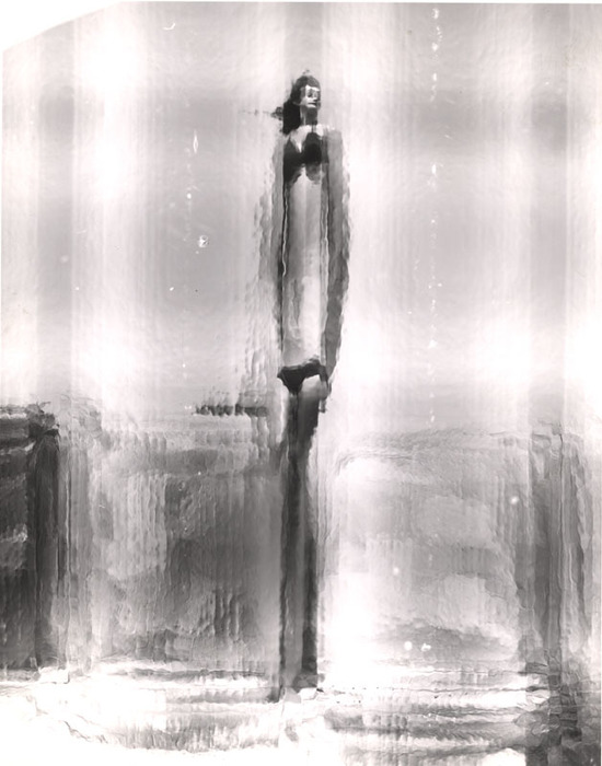 (Model on beach, wearing black bikini)