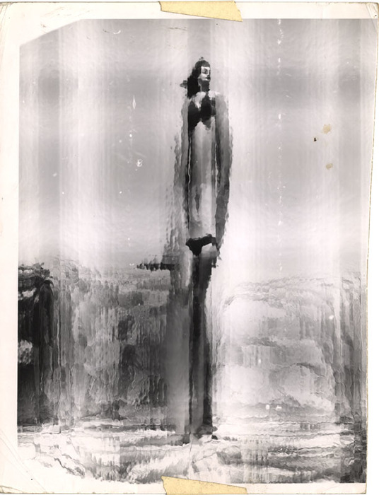 (Model on beach, wearing black bikini)