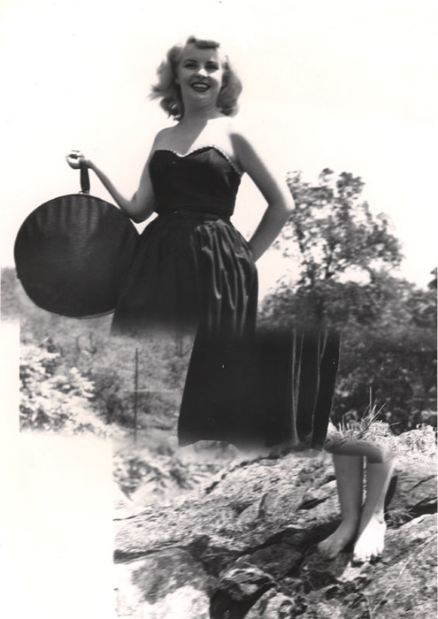 Blonde model on top of a rocky hill with round bag