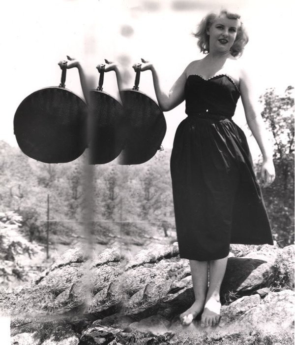 Blonde model on top of a rocky hill with round bag