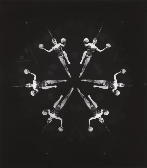 (Acrobat, hanging from her hair, with two balls)