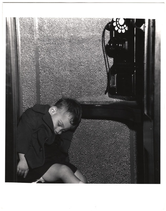 [Boy asleep in telephone booth on Navy Day, New York]