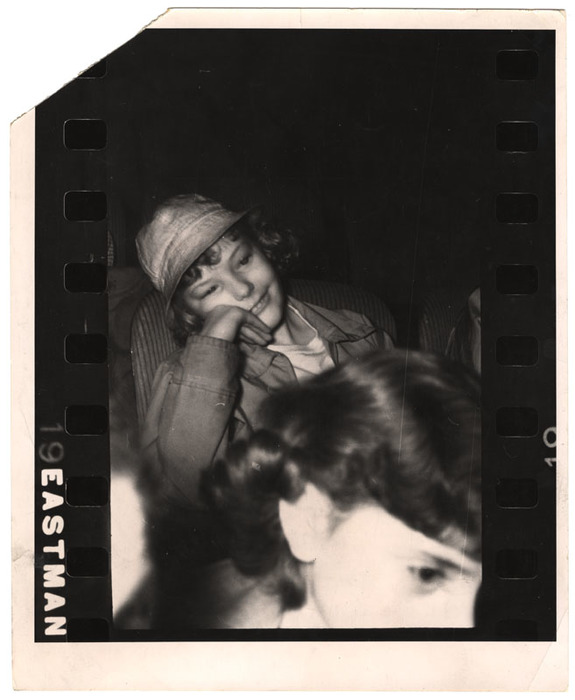 Girl wearing hat watching a movie in a theatre