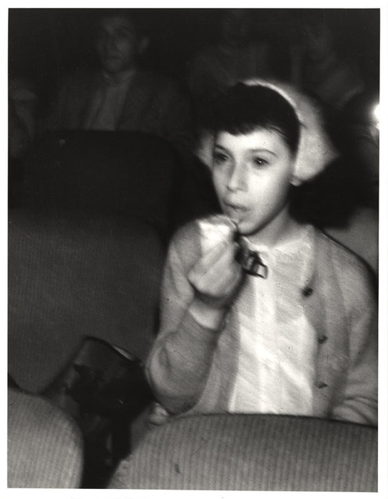Girl eating while watching a movie in a theatre