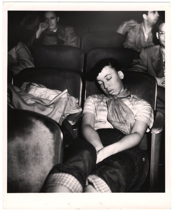 Young woman sleeping in a movie theatre
