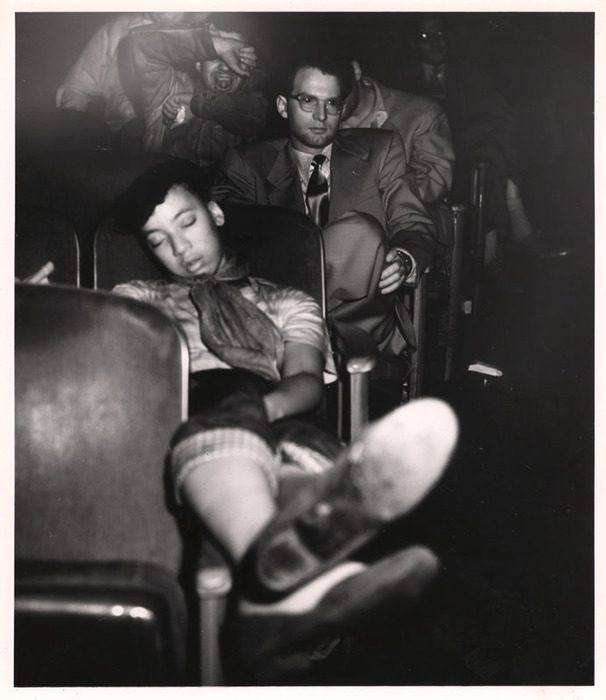 Young woman sleeping in a movie theatre