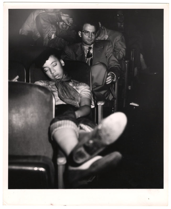 Young woman sleeping in a movie theatre