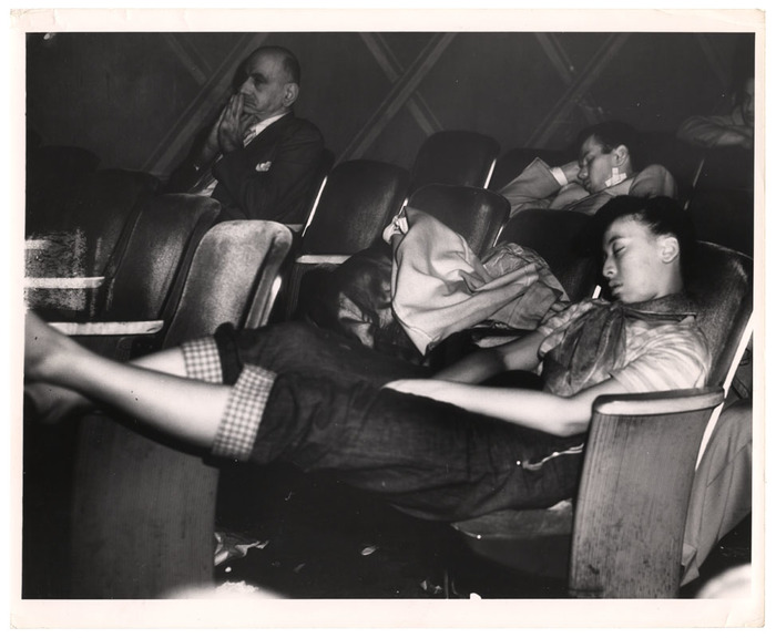 Young woman sleeping in a movie theatre