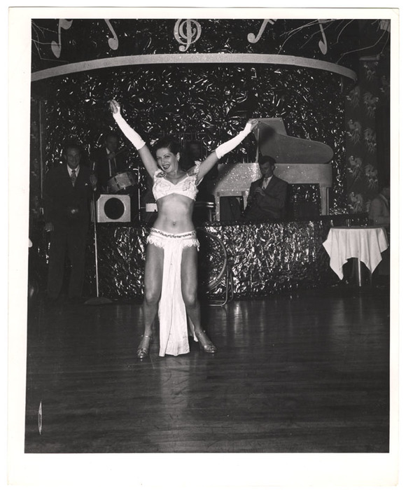 Showgirl dancing in front of band